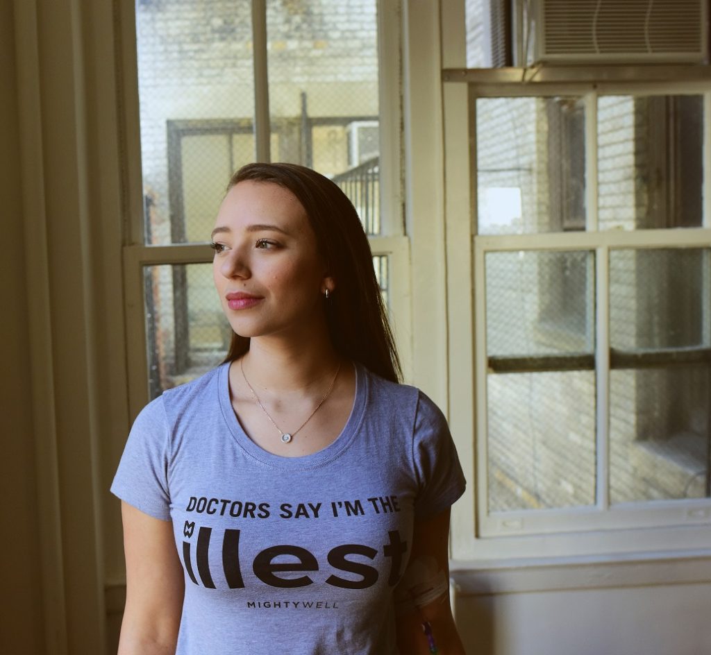 Emily Levy wearing a t-shirt that says "doctors say I'm the illess"